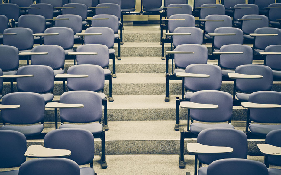An empty college lecture hall is pictured.