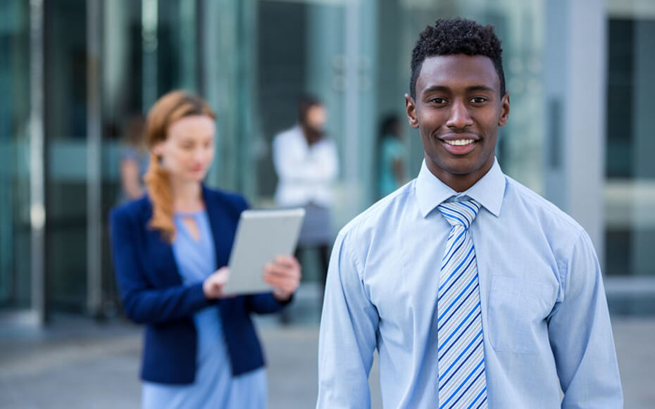 Black student smiling with blurred recruiter in background