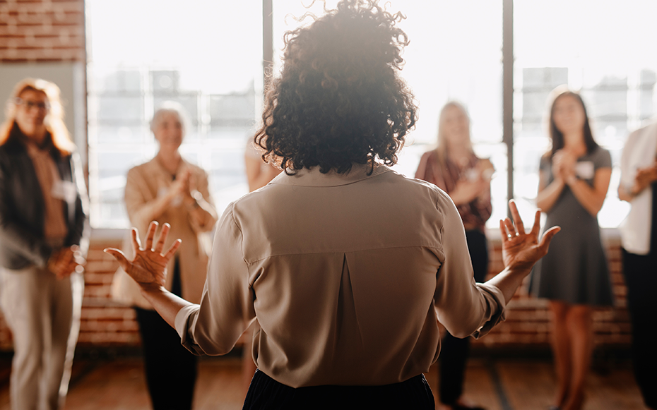 A woman speaking to a group of women about leadership.