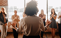 A woman speaking to a group of women about leadership.