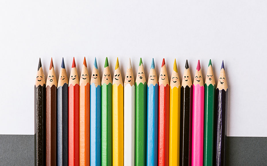 A group of different colored pencils with faces drawn on them.