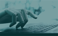 A robot hand does work on a laptop.