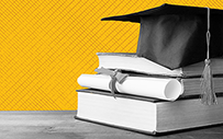 A graduation cap sits on top of a stack of books alongside a degree.