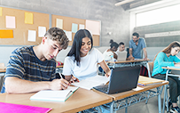 Two students working on a project together in a college classroom.