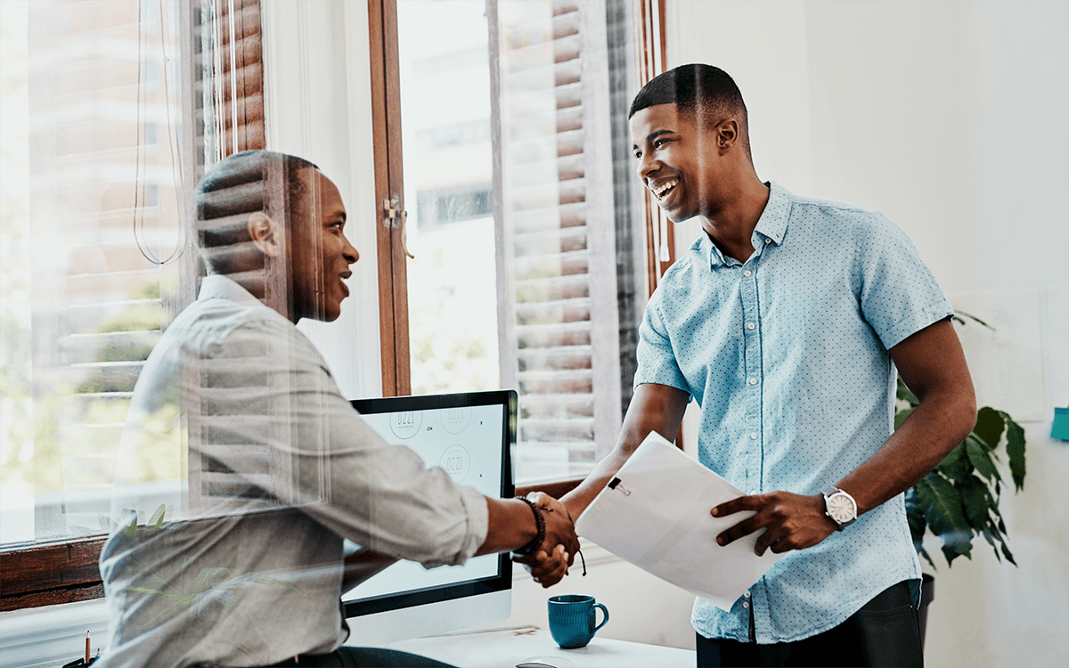 An employer shakes the hand of an intern.