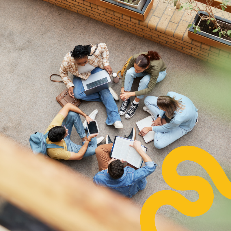 Students sitting in a circle on the ground.